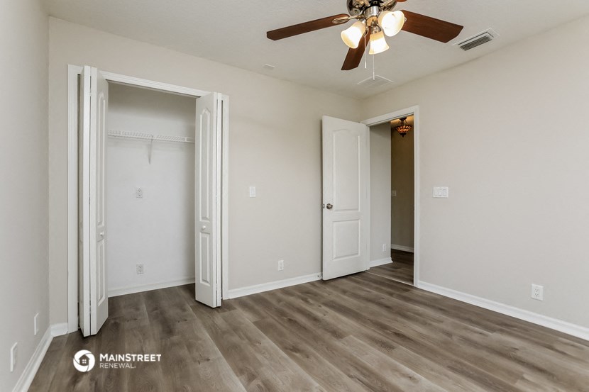 a bedroom with a ceiling fan and a closet