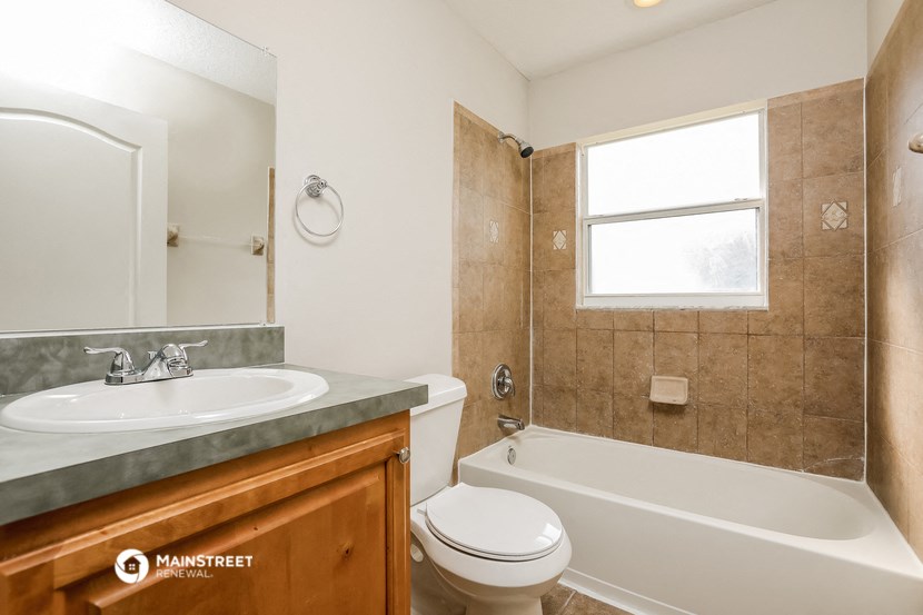 a bathroom with a sink toilet and bath tub and a window