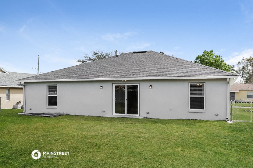 a white house with a gray roof and a yard