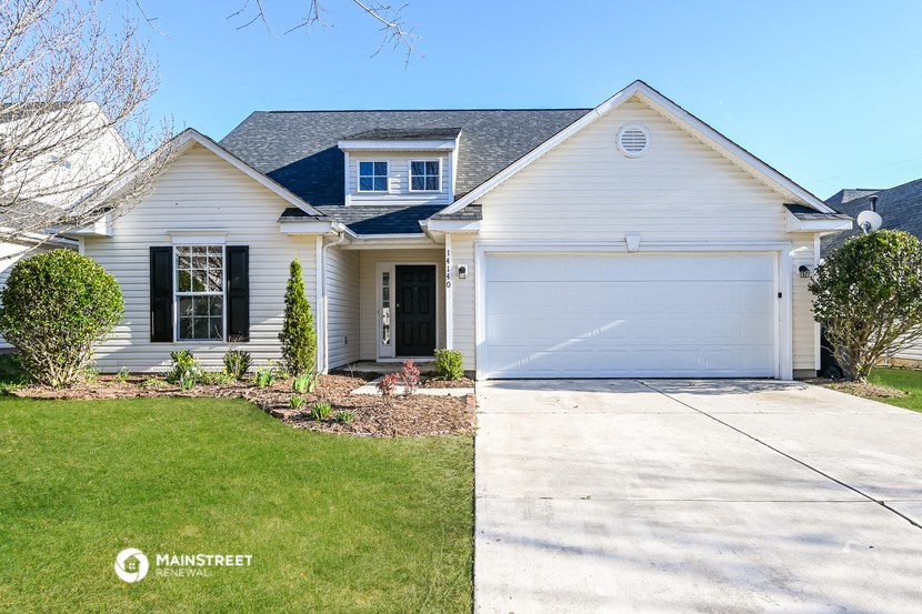 a white house with a white garage door and a lawn