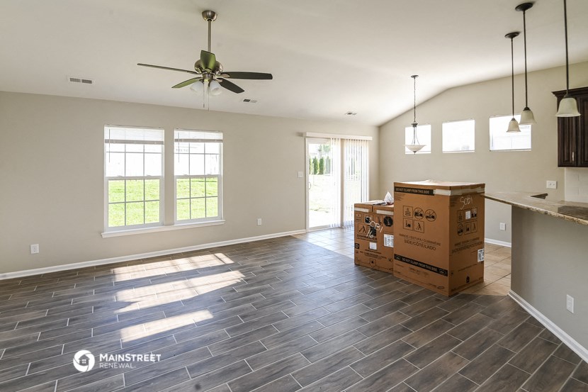 an empty living room with boxes on the floor