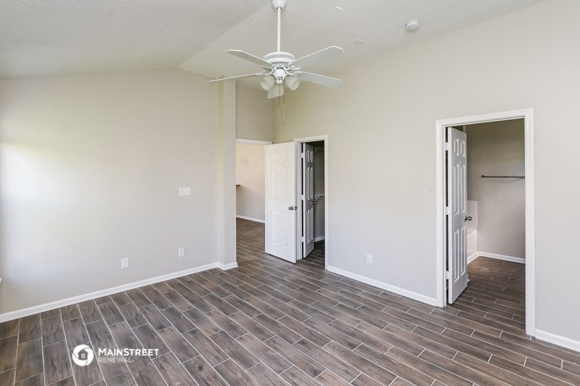 an empty living room with a ceiling fan