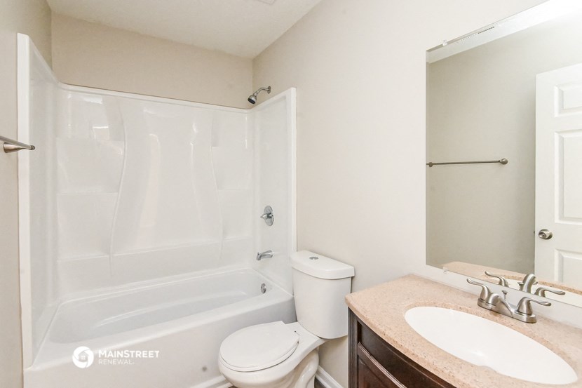 a bathroom with a shower toilet and sink and a mirror