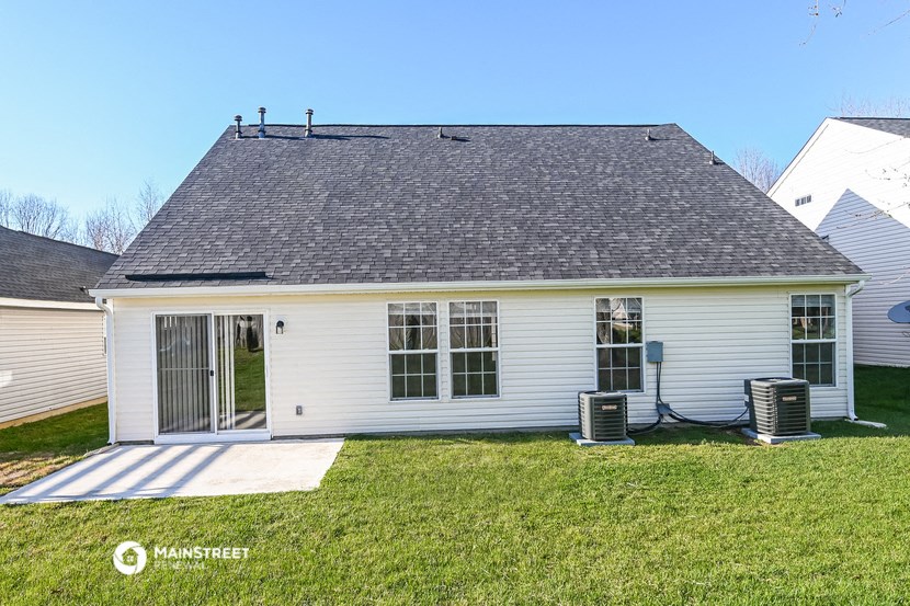 the front of a white house with a grey roof