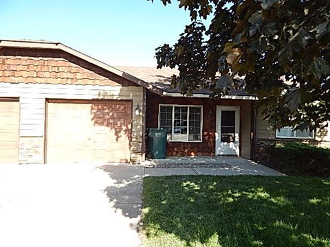a small brick house with a sidewalk in front of it