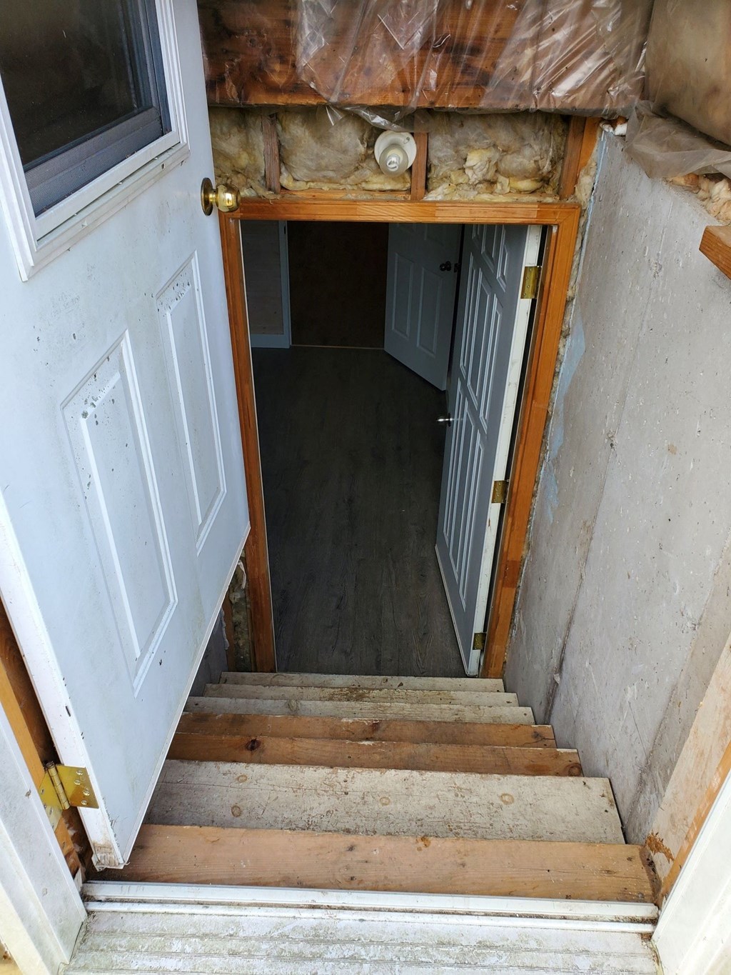 the stairway up to the basement with the door open