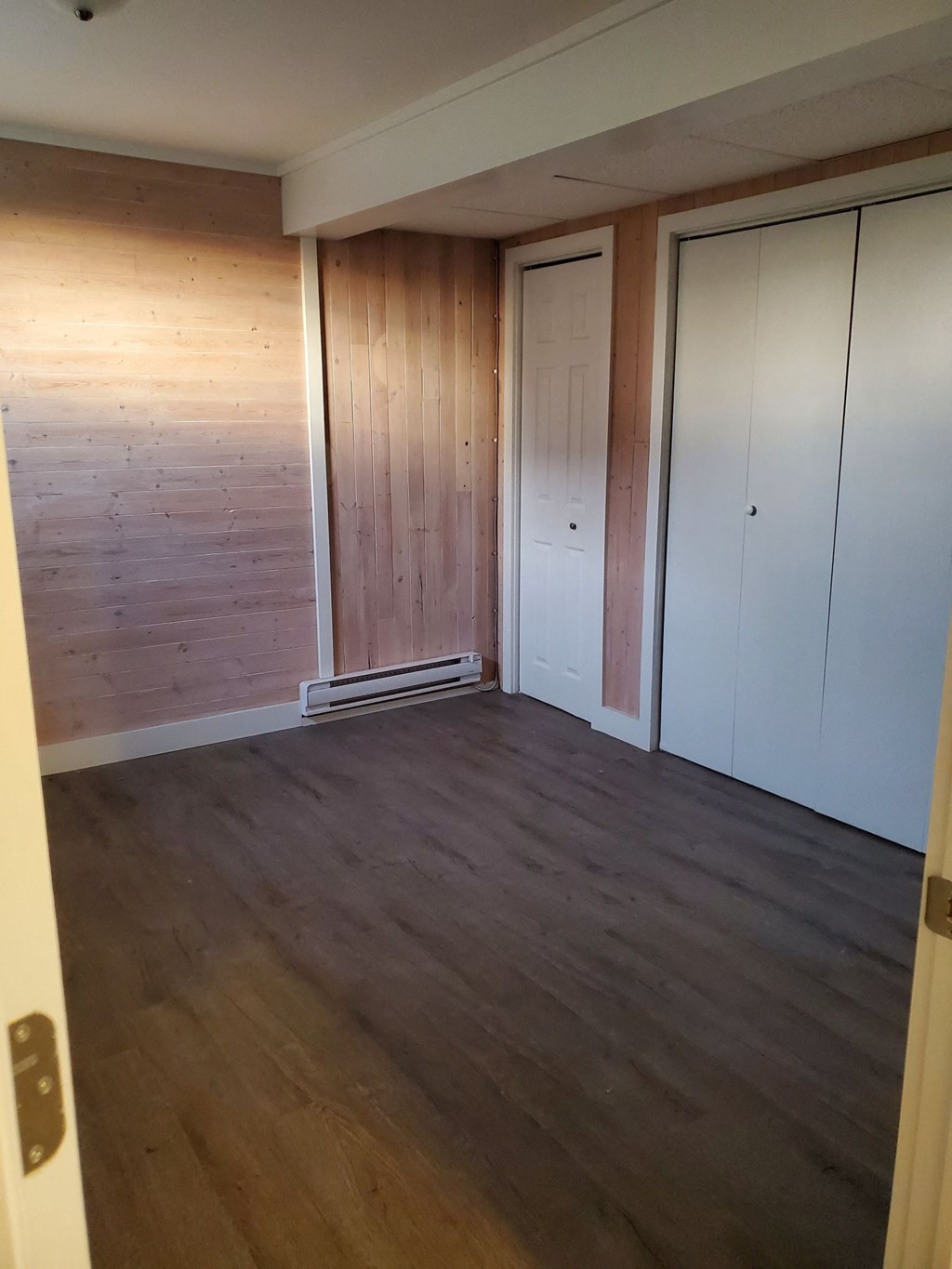 an empty room with wood floors and white closets