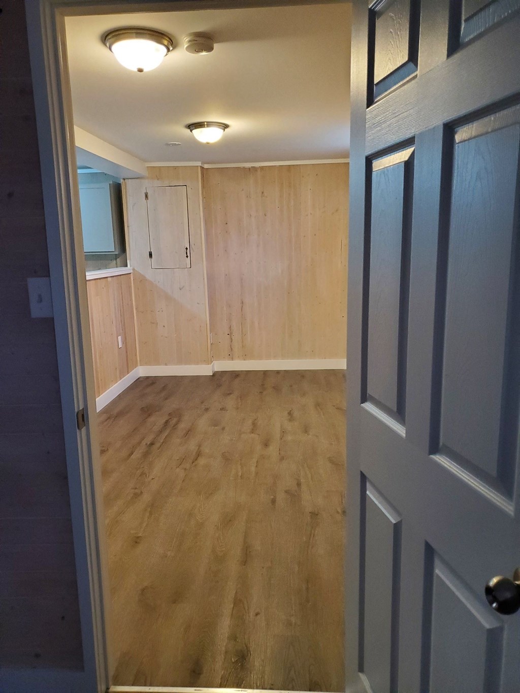 an empty room with wooden floors and a door