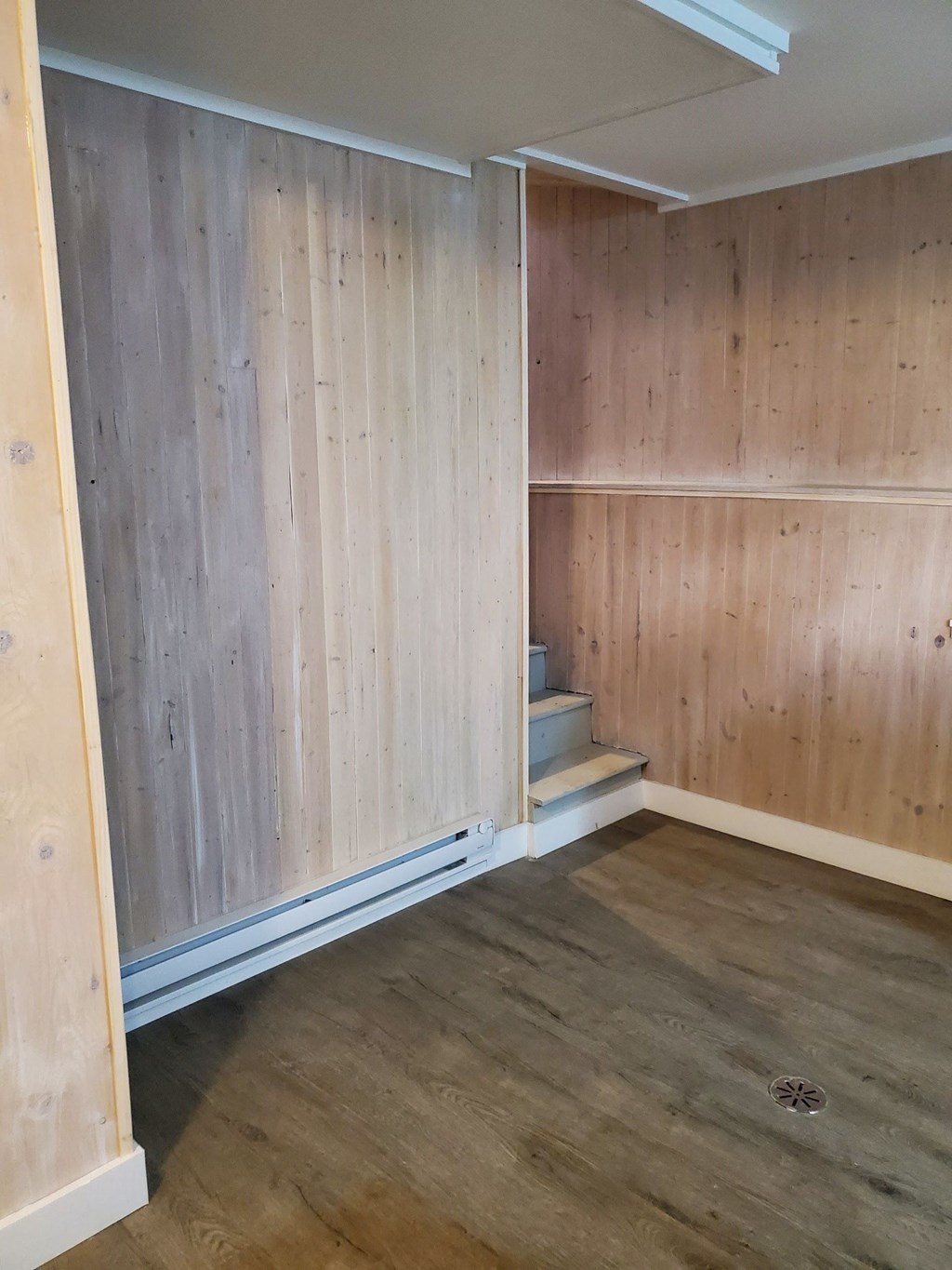 a room with wood paneling on the wall and a staircase