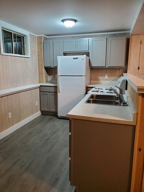 a small kitchen with white appliances and wooden cabinets