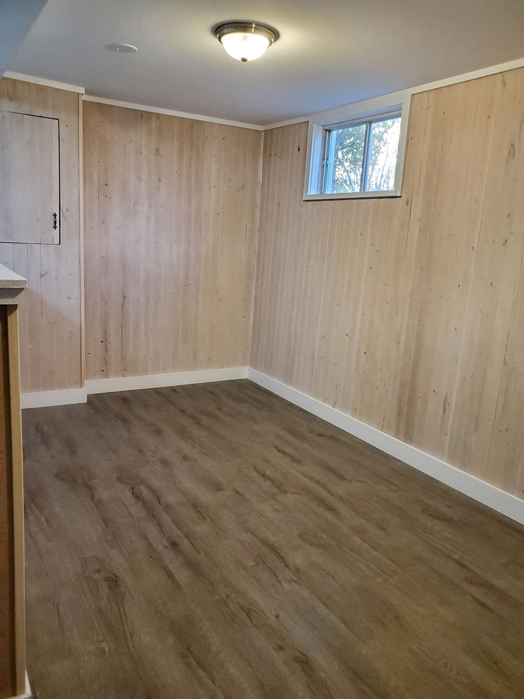 an empty room with wooden floors and a window