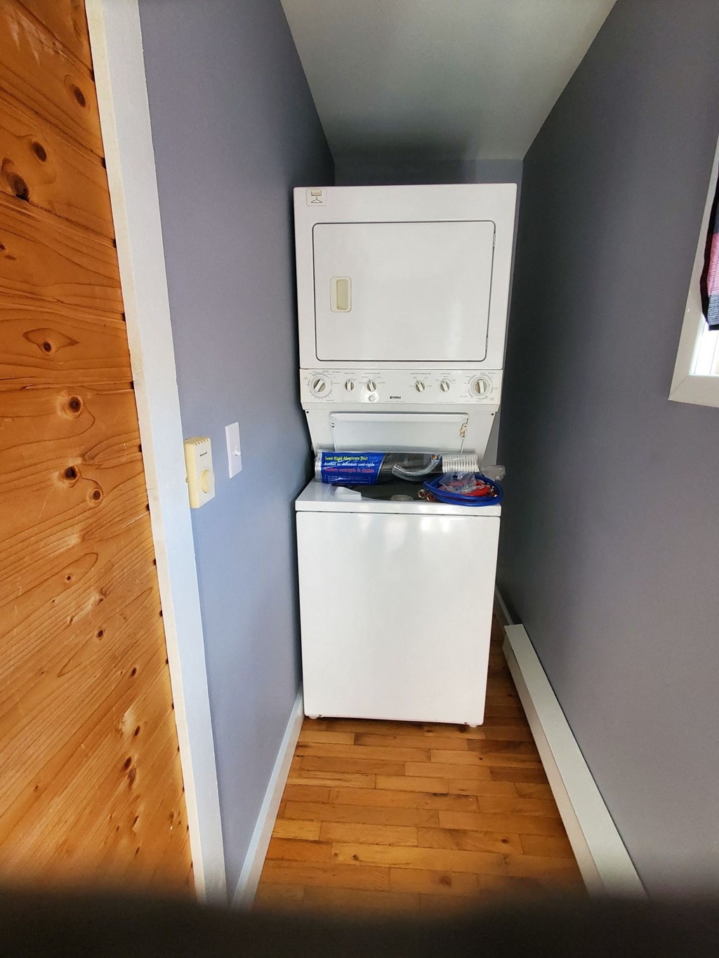 a washer and dryer in a room with a wooden floor