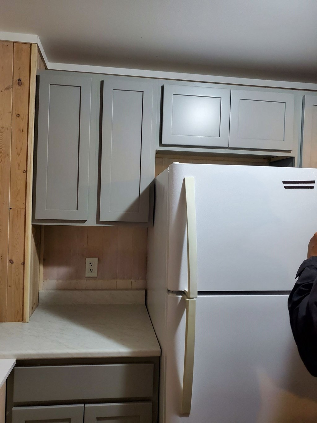 a kitchen with white cabinets and a white refrigerator
