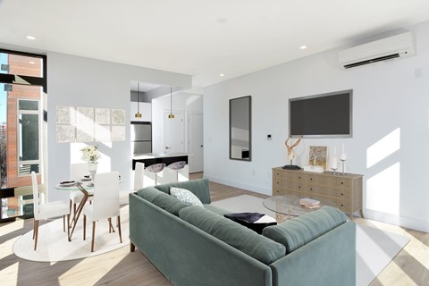 A modern living room with a green couch and a television.