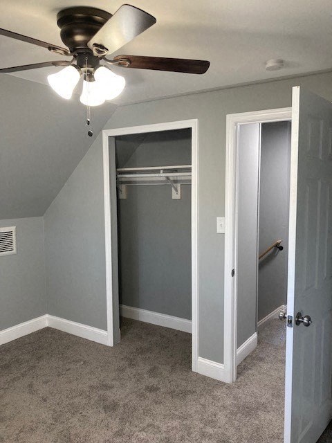 A room with a ceiling fan and a door leading to a bathroom.