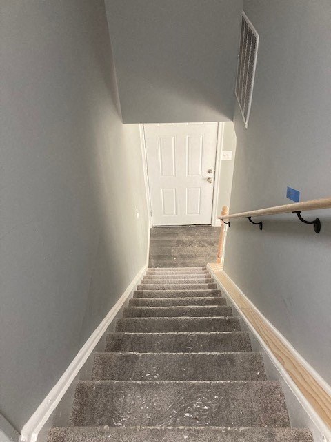 A staircase with a white door at the top.