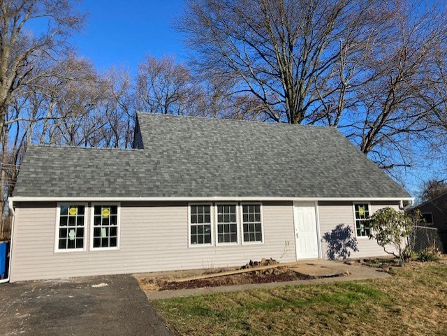 A small house with a grey roof and a white door.