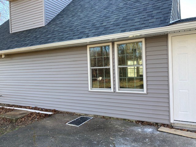 A house with a grey siding and a white door.