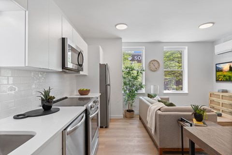 A modern kitchen with a dining area and a living room.