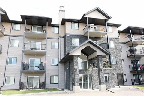 an apartment building with balconies and a roof