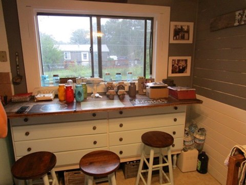a kitchen with three stools in front of a window