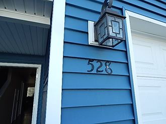 a blue house with a lamp on the side of it