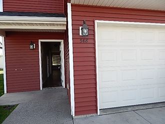 a red house with a white door and a white garage door