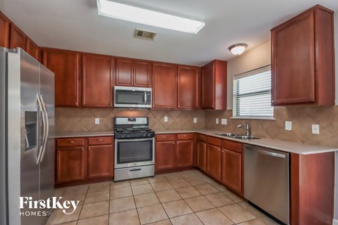 A kitchen with brown cabinets and a stainless steel refrigerator.