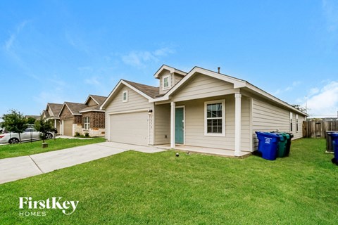 a beige house with a yard and a driveway