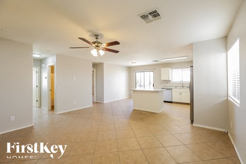 A spacious room with a ceiling fan and tiled flooring.