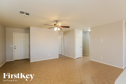 A spacious room with a ceiling fan and tiled flooring.