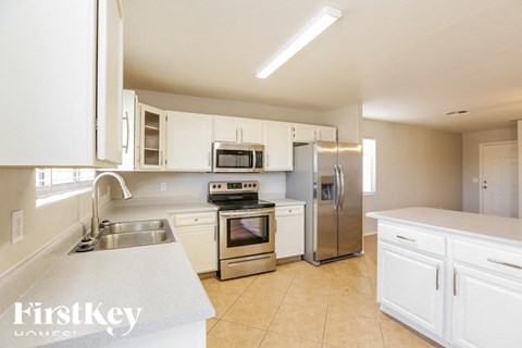A kitchen with white cabinets and appliances.