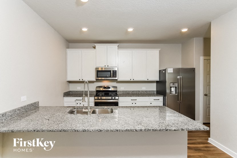 A kitchen with granite countertops and stainless steel appliances.