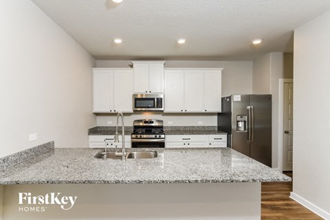 A kitchen with granite countertops and stainless steel appliances.