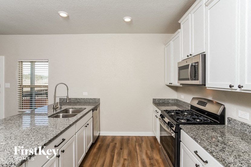 A kitchen with granite countertops and stainless steel appliances.