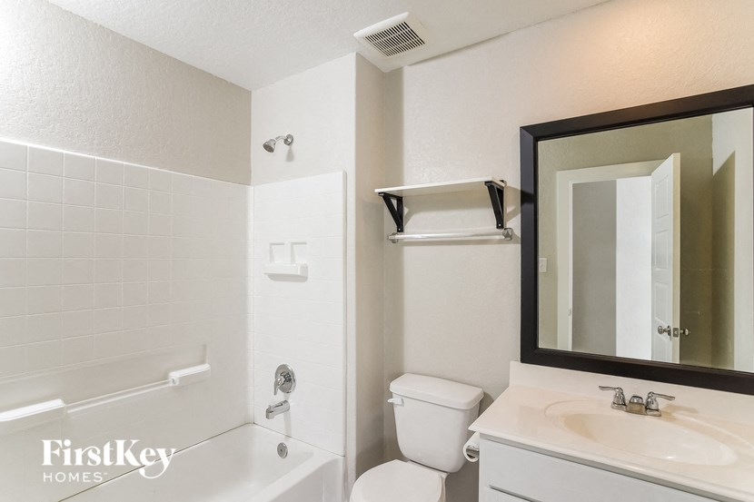 A white bathroom with a toilet, sink, and bathtub.