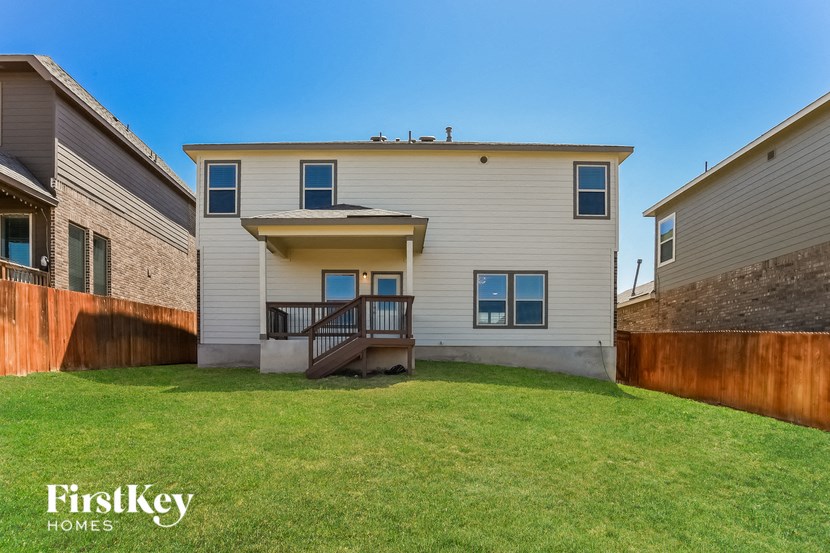 A house with a brown fence and a green lawn.
