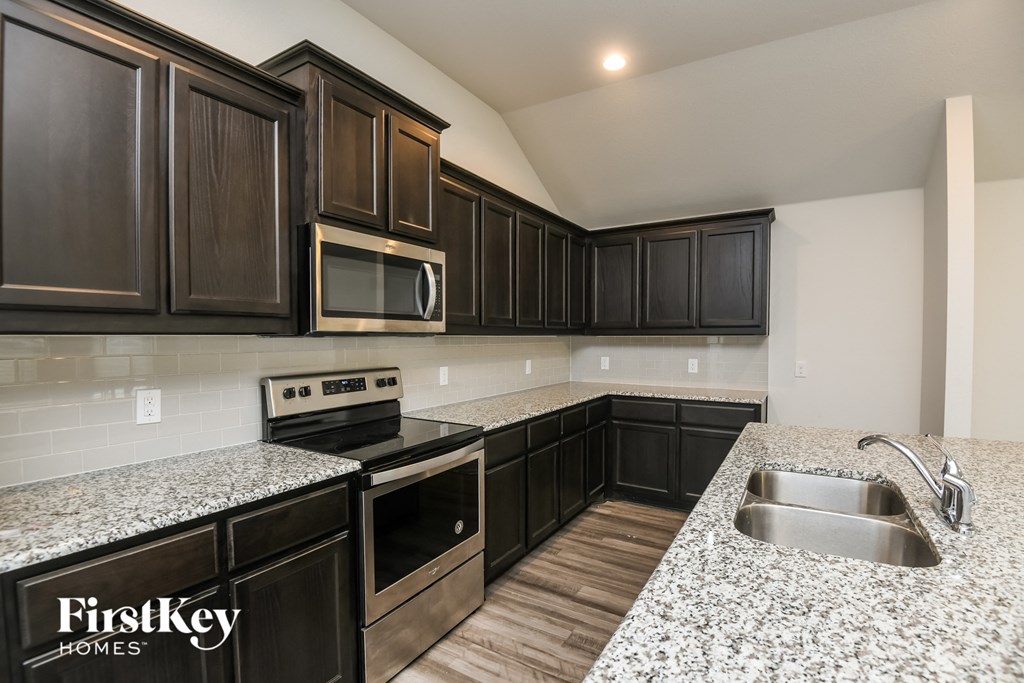 a kitchen with granite counter tops and black cabinets