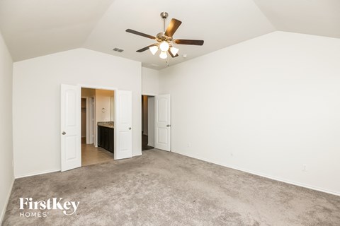 a living room with carpet and a ceiling fan