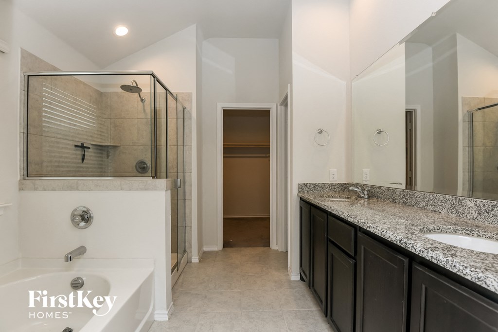 a master bathroom with a large shower and a sink and a bath tub