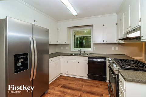 a kitchen with white cabinets and a stainless steel refrigerator