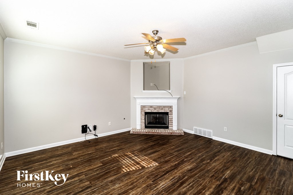 a living room with a fireplace and a ceiling fan
