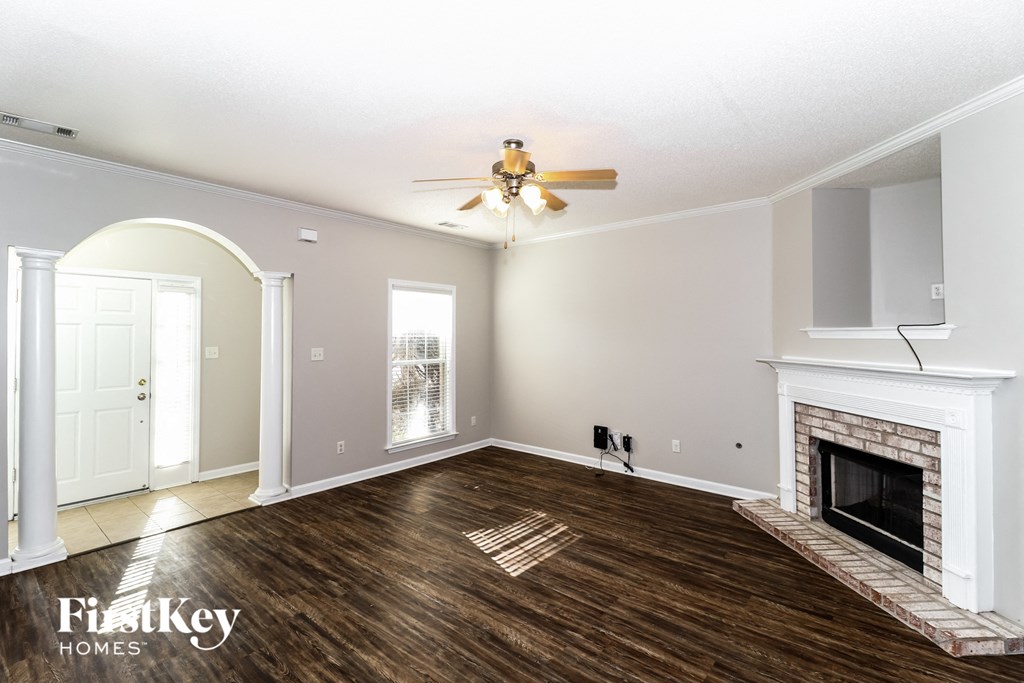 a living room with a fireplace and a ceiling fan