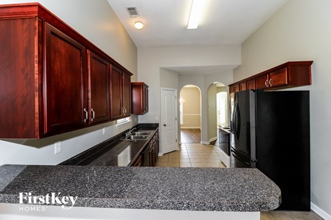 a kitchen with black appliances and granite counters and wood cabinets