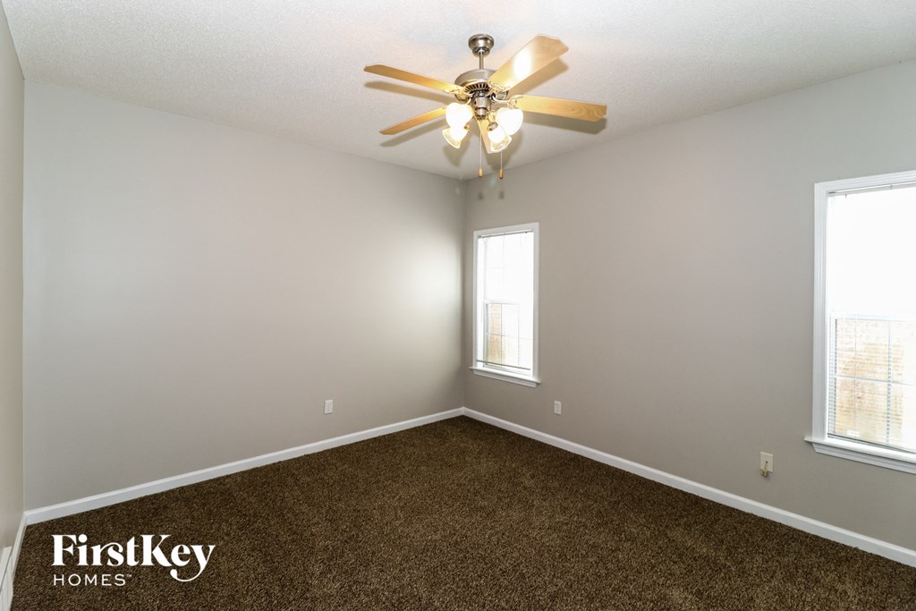 a bedroom with carpet and a ceiling fan