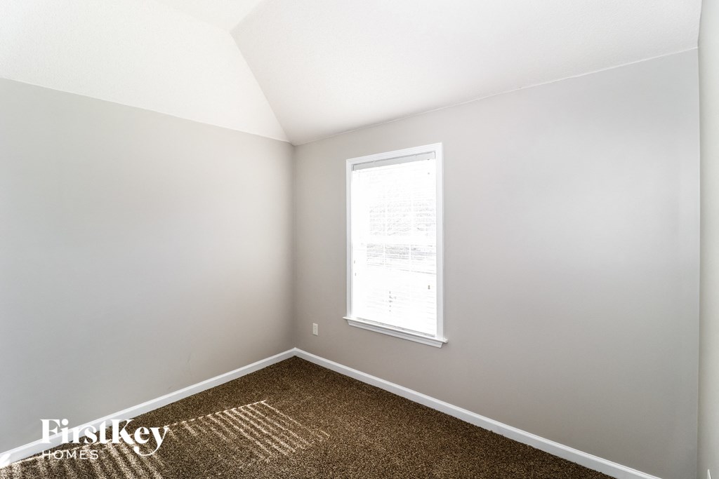 a small room with a window and a carpet