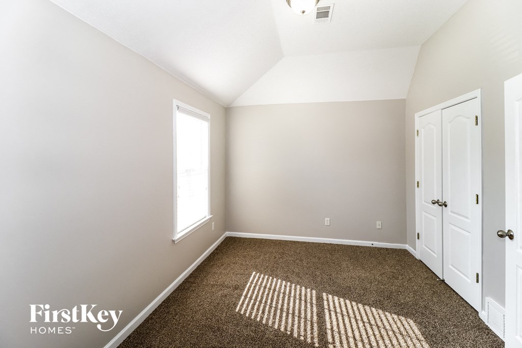 a bedroom with a carpeted floor and white doors