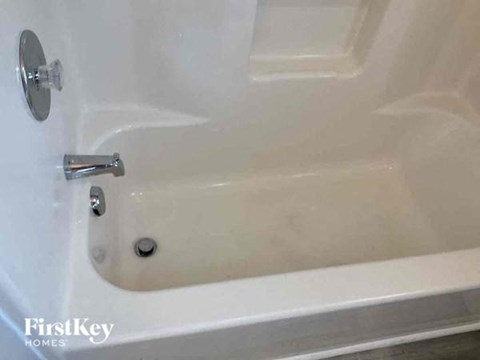 a white bath tub with a silver faucet