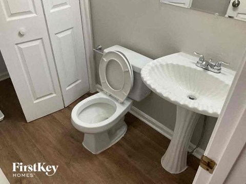 a white bathroom with a toilet and a sink