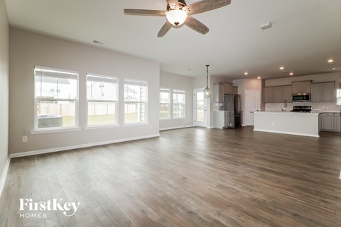 A spacious room with wooden floors and a ceiling fan.